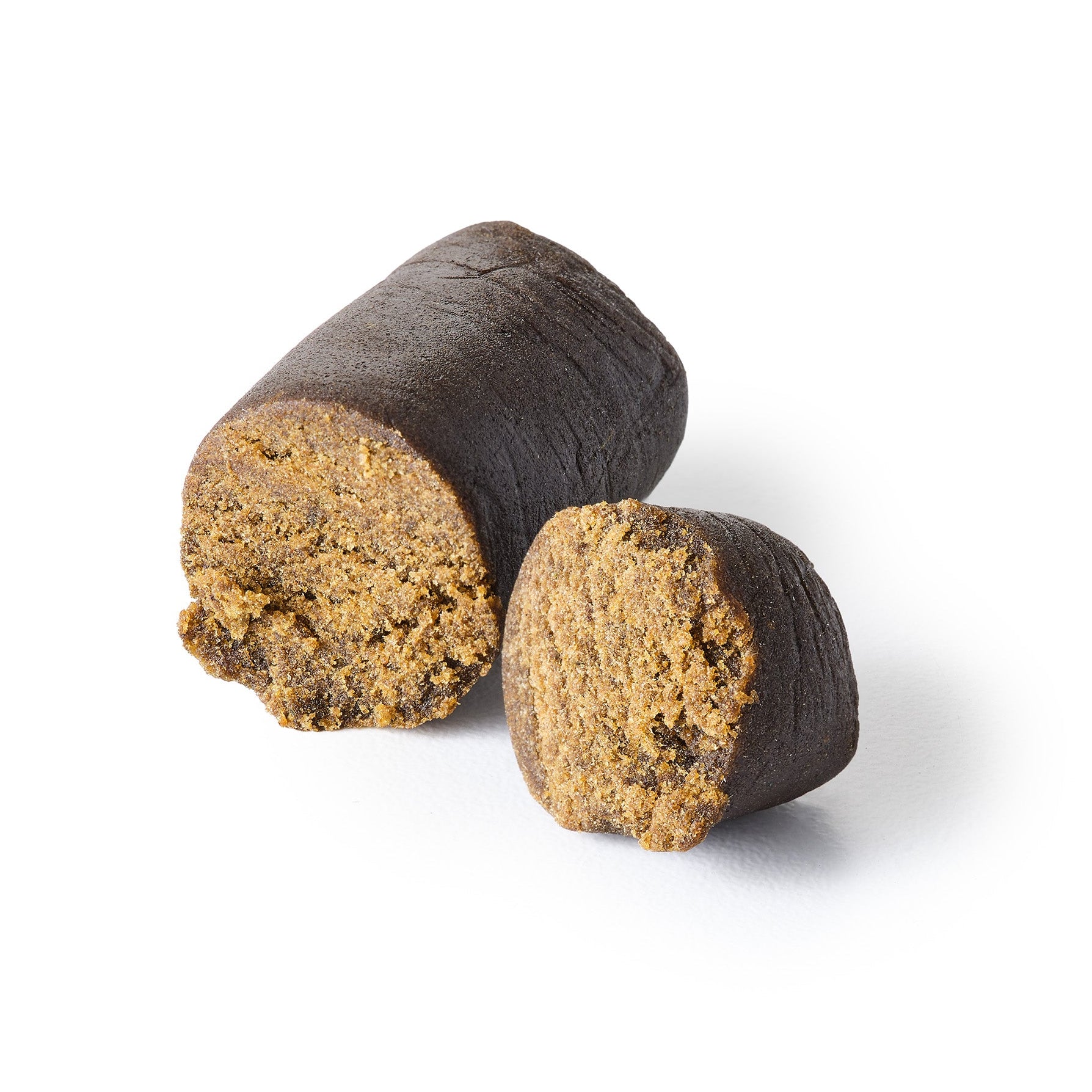 CBD hash with a rich olive hue, cut into two pieces to reveal the velvety texture inside.